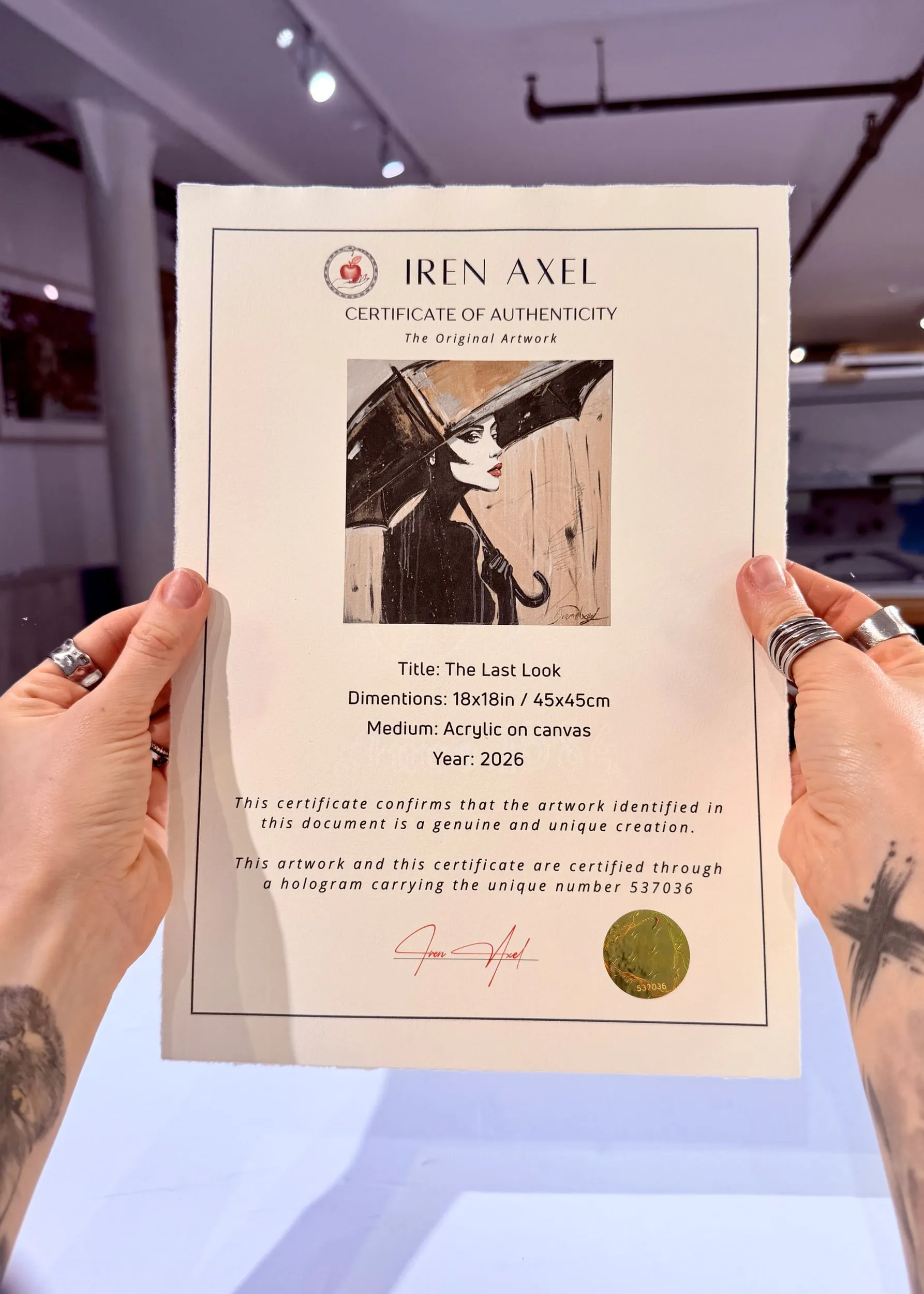 The signed certificate of authenticity for The Last Look, hologram number 537036, held up in the gallery